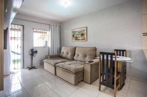 a living room with a couch and a table at Casa com piscina, wifi e churrasqueira em unamar. in Tamoios