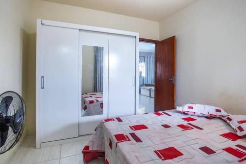 a bedroom with a bed with a glass wall at Casa com piscina, wifi e churrasqueira em unamar. in Tamoios