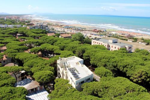 an aerial view of a resort with trees and the beach at Hotel Rosmarina in Marina di Grosseto