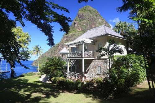 a house on a hill next to the ocean at Arc en Ciel in Soufrière