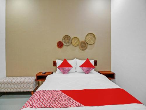 a bedroom with a bed with a red and white blanket at OYO 90820 Madania Guesthouse Syariah in Mataram