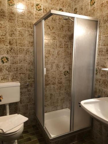 a bathroom with a shower and a toilet and a sink at Sportpension Therese in Westendorf