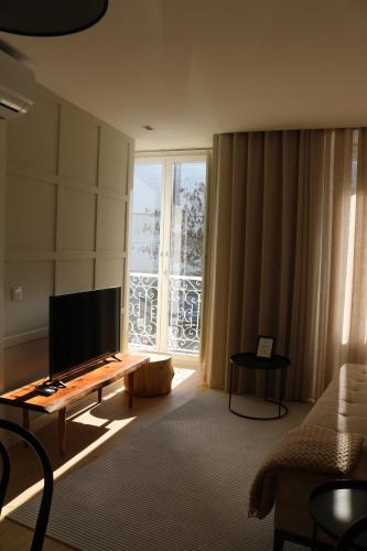 a living room with a television and a large window at Villa Graça -Hostels and Apartments in Santarém