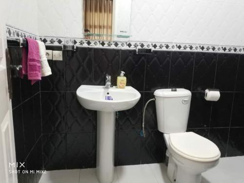 a bathroom with a white toilet and a sink at Beach View Apartment (Boulevard Mohammed VI) in Tangier