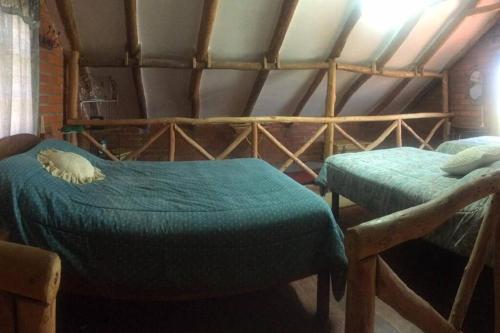 a room with two beds in a room with a roof at Cabaña a orillas del Lago in Tarija