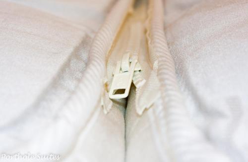 a close up of a white bed with a pair of pulls at Porthole Suites in Saint Aubin