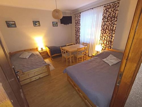 a room with two beds and a table and a dining room at U Eli I Tomka in Krzyżowa