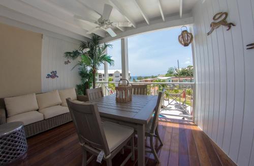 a living room with a table and chairs and a couch at Lantana Barbados Condos in Saint James