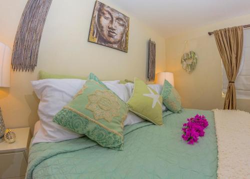 a bed with a bunch of pillows on it at Lantana Barbados Condos in Saint James
