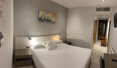 een slaapkamer met een wit bed in een kamer bij Hostal El Palomar in Tomelloso