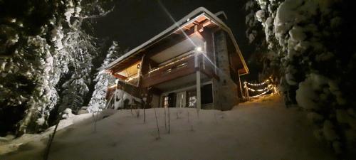 a log cabin in the snow at night at Rukan Ukkoteeri 1 & 2 in Ruka