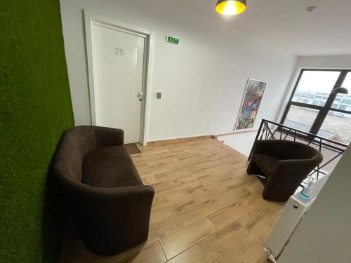 a living room with two chairs and a green wall at ALPIN rooms in Topliţa