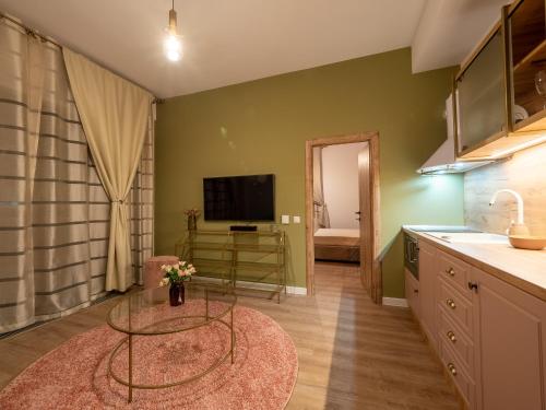 a kitchen with a table and a tv in a room at Signature Aparthotel - Boutique in Galaţi