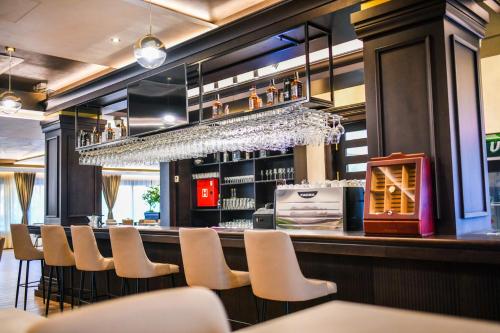a bar with a row of white chairs and a counter at Zlatna Kruna in Banja Luka