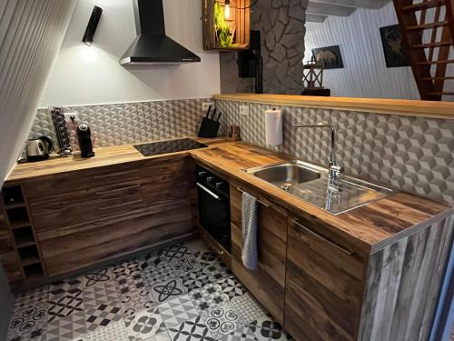 une cuisine avec un évier et un plan de travail dans l'établissement Chalet du Fayard - jacuzzi avec vue et détente en pleine nature, à Belfahy