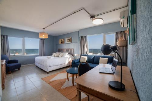 a hotel room with a bed and a desk with a laptop at Selina Punta Del Este in Punta del Este