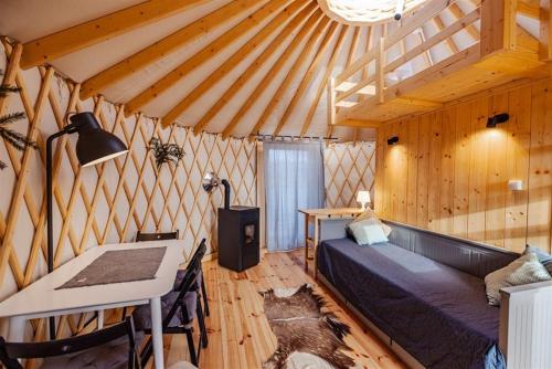 Zimmer mit einem Bett und einem Tisch in einem Zelt in der Unterkunft Cztery Stawy Glamp - Jurty i Namioty Safari in Ruda Różaniecka