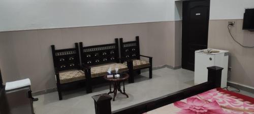 a living room with two benches and a table at Hotel Shelton Palace in Multan