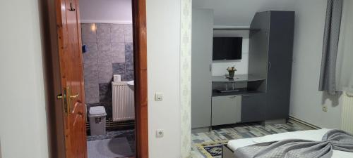a room with a bathroom with a shower and a bed at Pensiunea Casa Ady in Bran