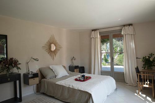 une chambre avec un grand lit et une fenêtre dans l'établissement Villa provençale au cœur du pays d’Aix, piscine, vue imprenable, à Saint-Antonin-sur-Bayons