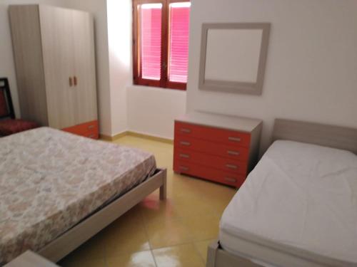 una camera con due letti, un comò e uno specchio di Casa Vacanze De Simone San Marco di Castellabate a Castellabate
