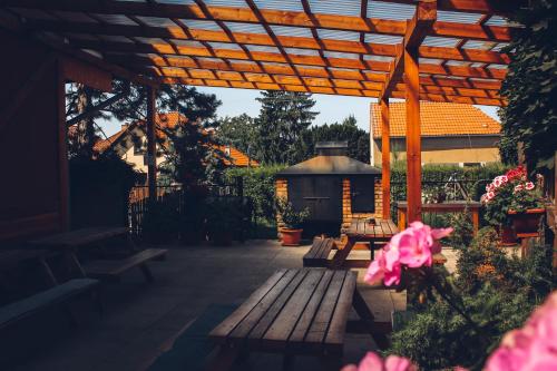 a patio with benches and a wooden pergola at Penzion Na Vošverku in Čelákovice