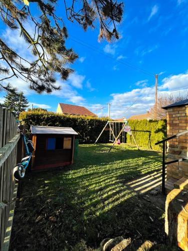 a backyard with a dog house and a playground at Penzion Na Vošverku in Čelákovice