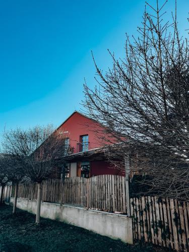 a red house with a fence in front of it at Penzion Na Vošverku in Čelákovice