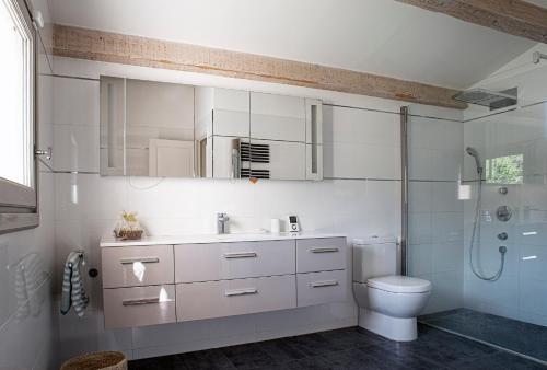 une salle de bain blanche avec des toilettes et un lavabo dans l'établissement Villa provençale au cœur du pays d’Aix, piscine, vue imprenable, à Saint-Antonin-sur-Bayons