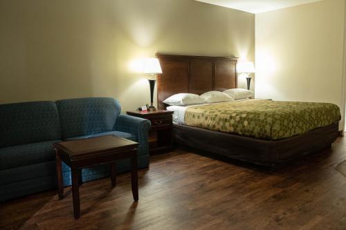 a hotel room with a bed and a couch at Econo Lodge Near Fort Gregg-Adams I-295 in Hopewell