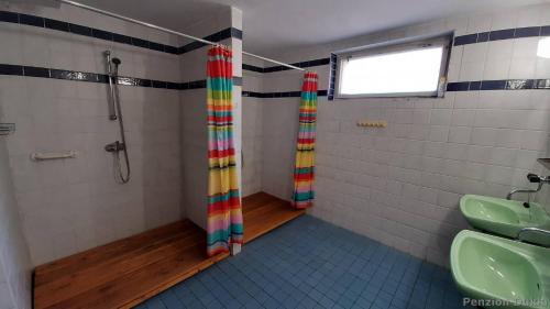 a bathroom with a shower with a rainbow shower curtain at Penzion Dukla in Mariánská