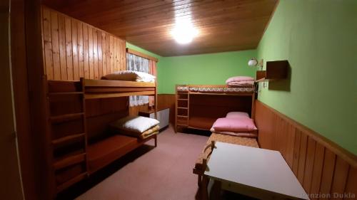 MariánskáにあるPenzion Duklaの小さなお部屋で、二段ベッド3組、テーブルが備わります。