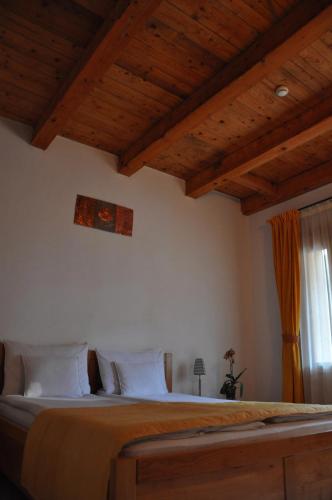 a bedroom with a large bed with wooden ceilings at Vila Sara/Adult Only in Sovata