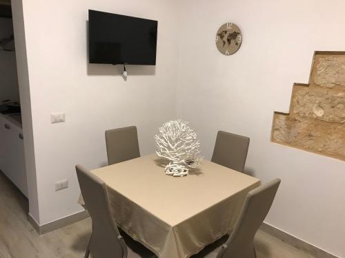 a dining room with a table with chairs and a television at Casa Tonino in Porto Cesareo