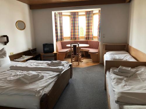 a hotel room with two beds and a table and chairs at Sportpension Therese in Westendorf