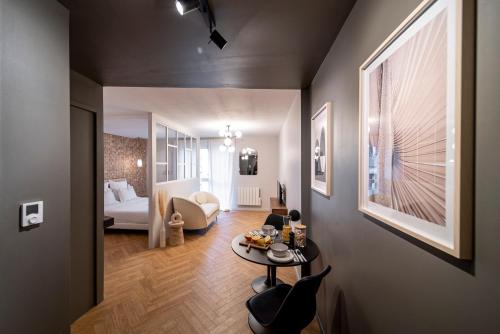 un salon avec un lit et une table dans l'établissement Suite Georgia - Check in h24 - Wifi, à Villeurbanne