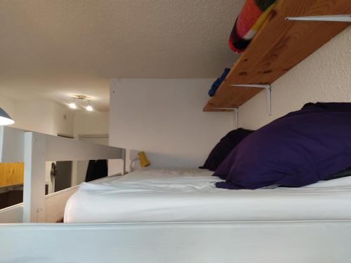 een slaapkamer met een wit bed en een ladder bij PETIT STUDIO 17 M2 in La Foux