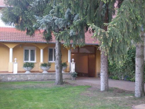 une maison avec deux arbres devant elle dans l'établissement Galéria Panzió, à Nagykanizsa