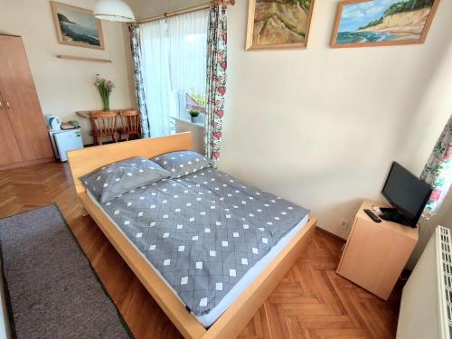 a small bedroom with a bed in a room at Willa Karwia in Karwia