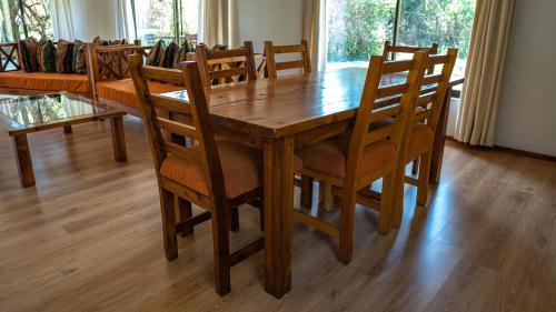 a wooden dining room table with chairs and a couch at The Senna House in Nakuru