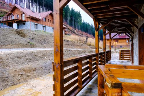 a wooden pavilion with a fence and a building at Apartmány Valča in Valča