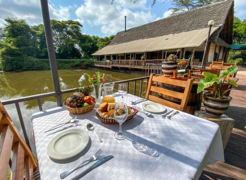 a white table with a basket of fruit and a building at The Senna House in Nakuru