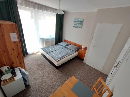 a small bedroom with a bed and a window at Willa Karwia in Karwia