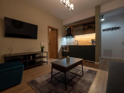 a living room with a table and a tv on the wall at Signature Aparthotel - Boutique in Galaţi