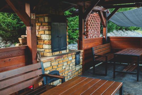 a porch of a cabin with benches and a green door at Glamping Pod Gwiazdami in Pietrusza Wola