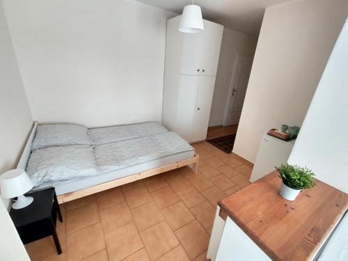 a small bedroom with a bed and a table at Willa Karwia in Karwia