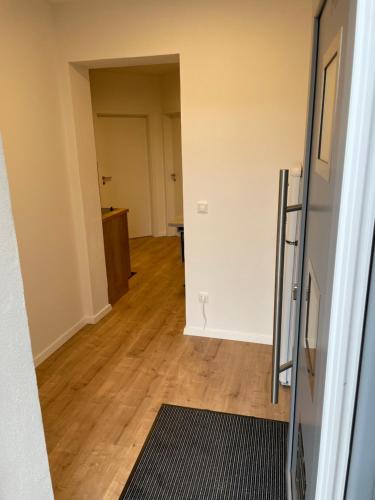 an empty room with a hallway with wooden floors at Pension Alte Schule in Langenbernsdorf