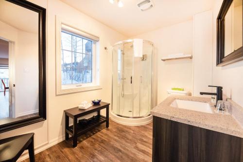 a large bathroom with a shower and a sink at Auberge Sous les Arbres in Gaspé