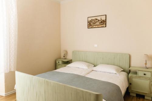 a bedroom with a bed and two night stands and a window at Vila Ana in Štanjel