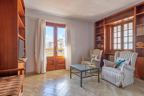 a living room with two chairs and a table at BRESSOL DELUXE Apartments in Port de Pollensa